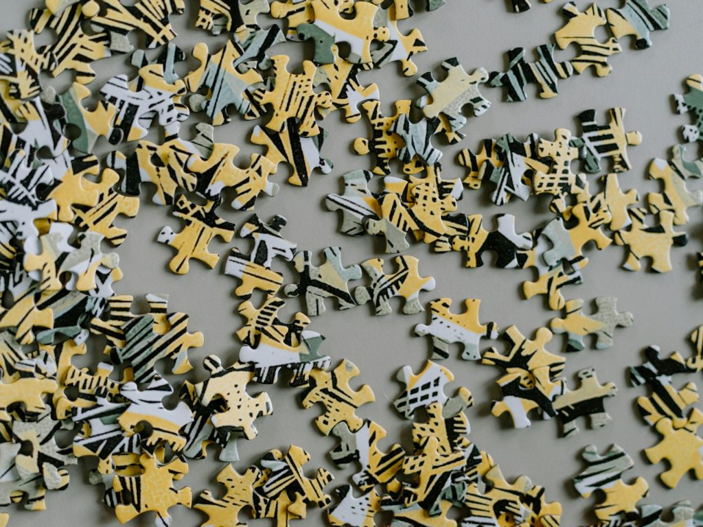 Scattered puzzle pieces with yellow and grey abstract patterns on a table