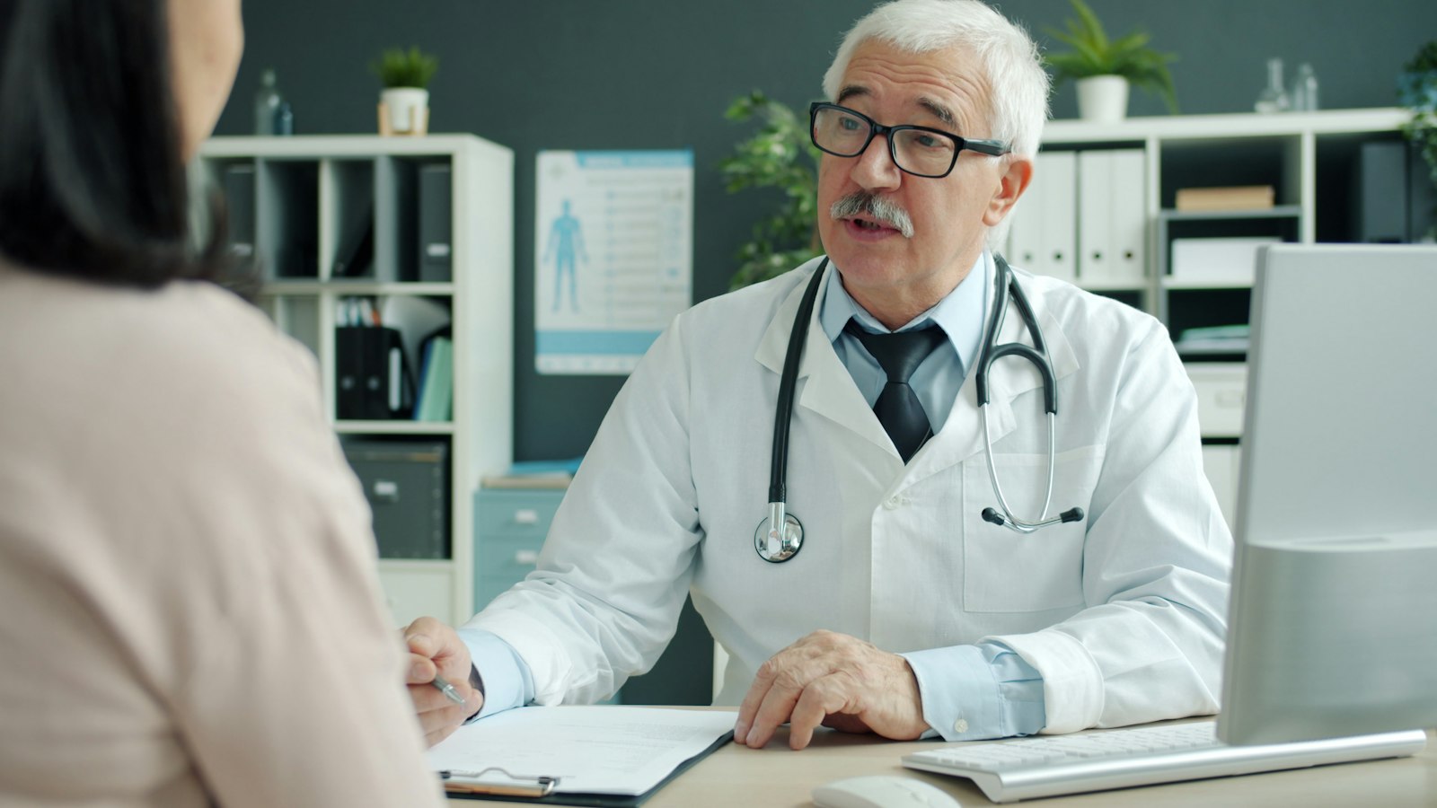 A doctor listening to a female patient during a consultation in a medical office