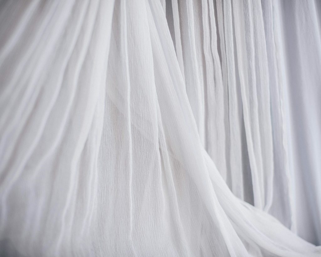 White, airy fabric flowing in soft folds, symbolising lightness and couture craftsmanship