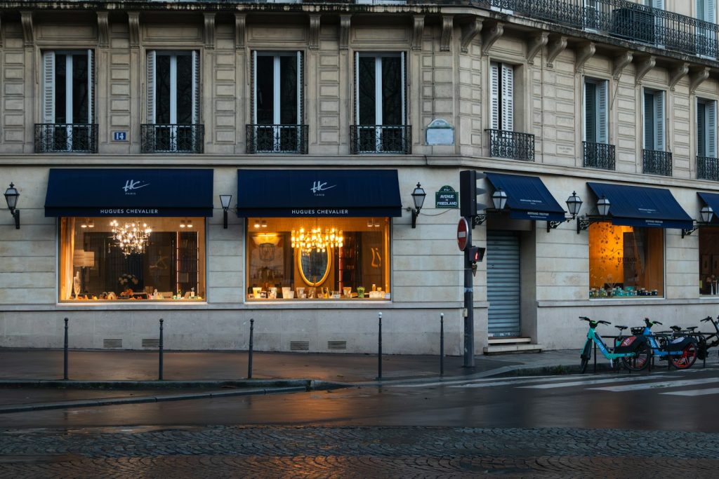 Storefront with blue awnings and lit windows on Avenue de Friedland in Paris at dusk