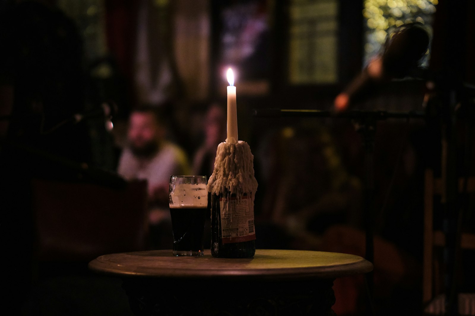 A single lit candle on a table in a dark, moody room