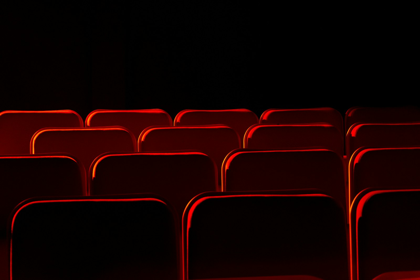 Rows of empty red cinema seats in a dark auditorium, symbolic image for a documentary release