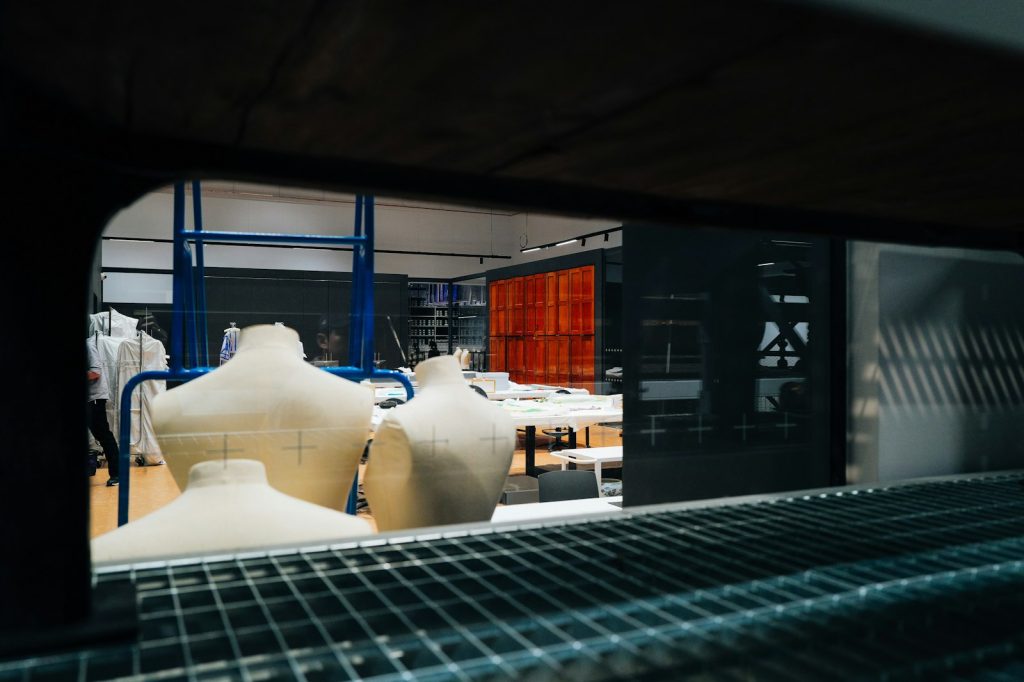 Dress mannequins and sewing supplies in a dimly lit clothing workshop