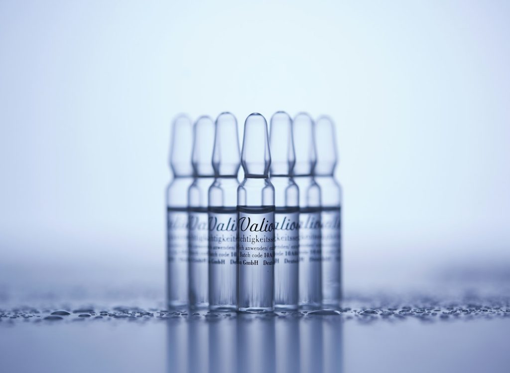 A row of small clear glass vials on a light table, symbolising the debate about experimental peptides