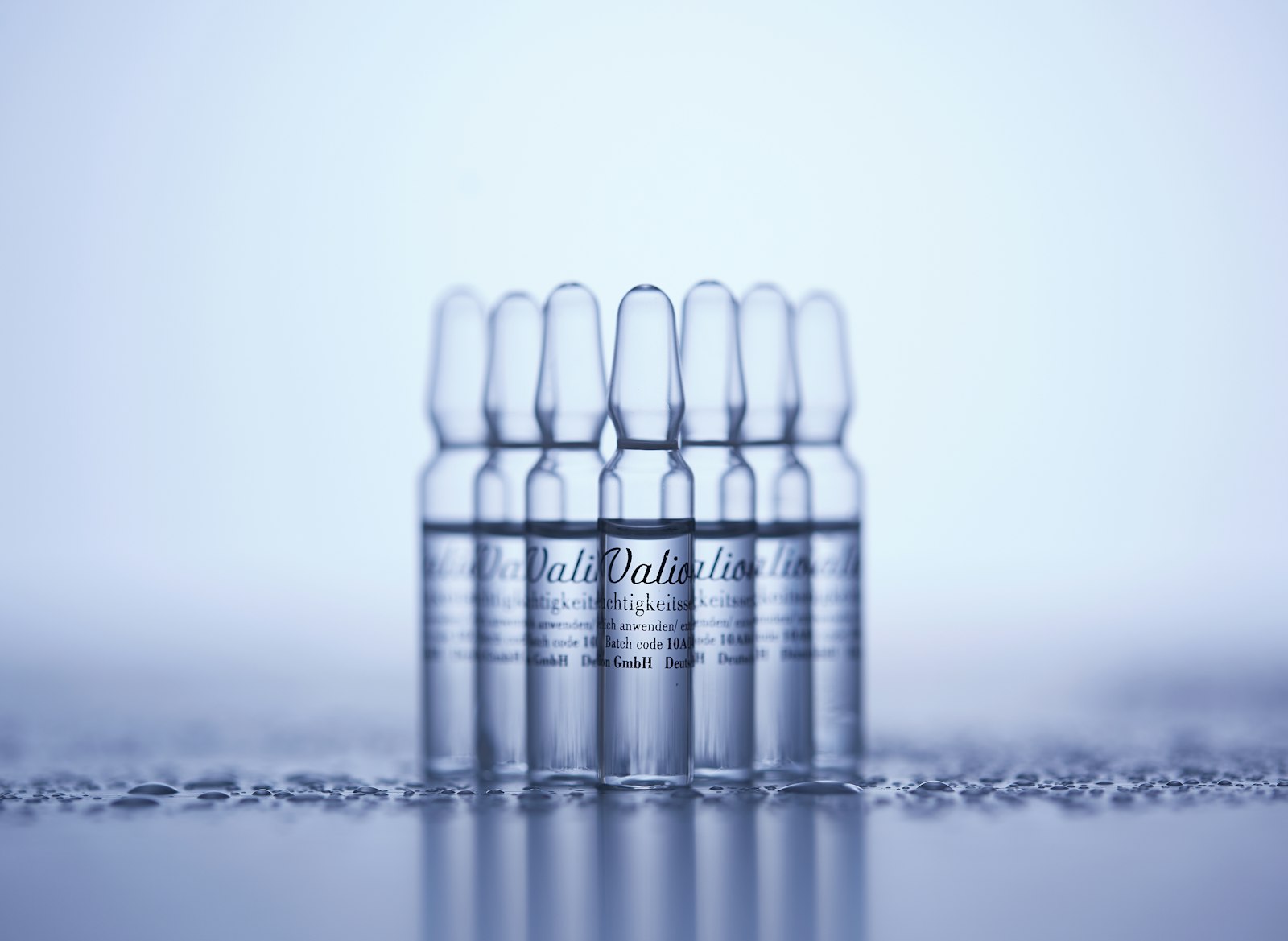 A row of small clear glass vials on a light table, symbolising the debate about experimental peptides