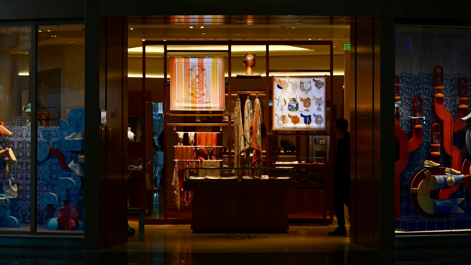 Illuminated luxury boutique window display at night on a city street