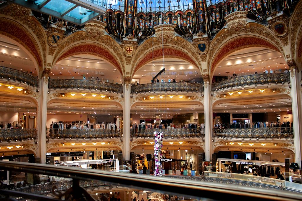 Grand ornate interior of a historic department store with arches and warm light