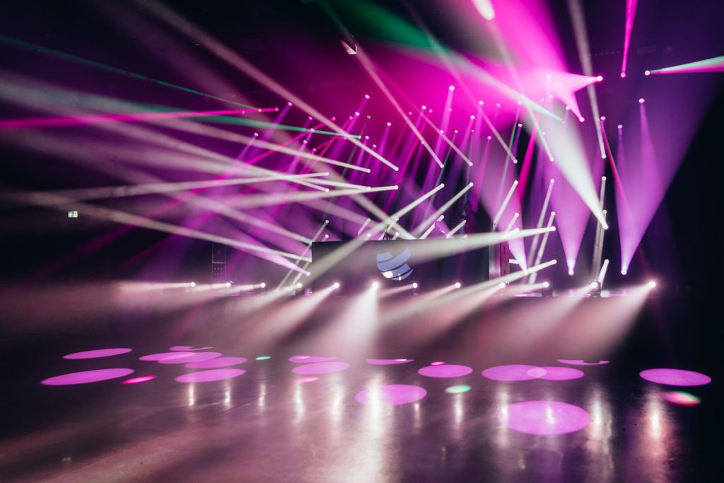 Empty concert stage bathed in purple and blue spotlights