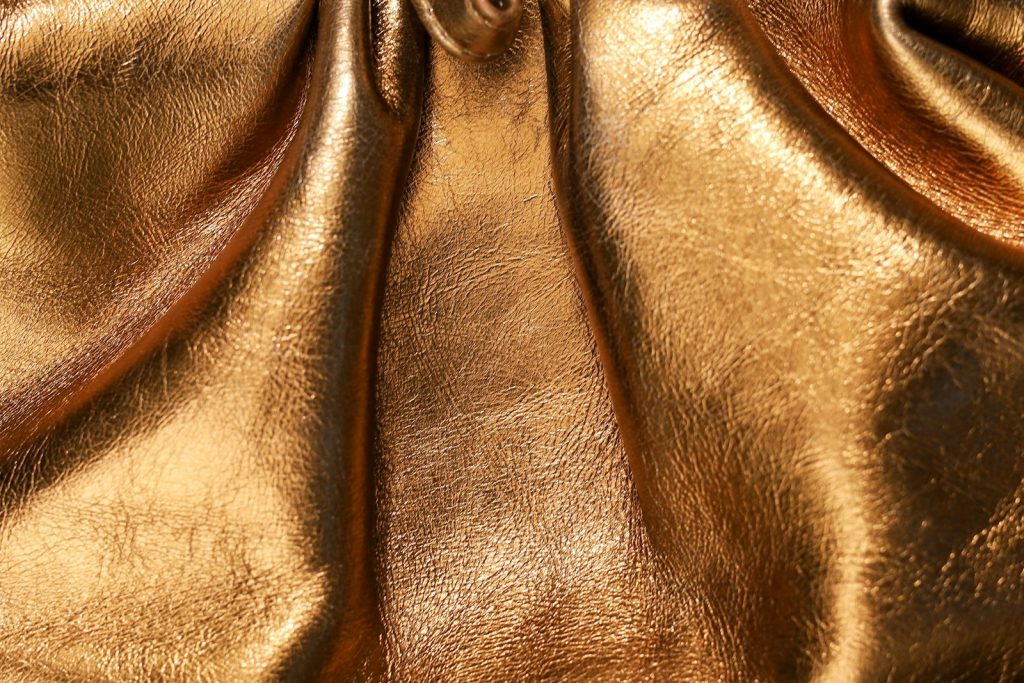Close-up of a textured golden fabric with soft folds and a warm metallic sheen
