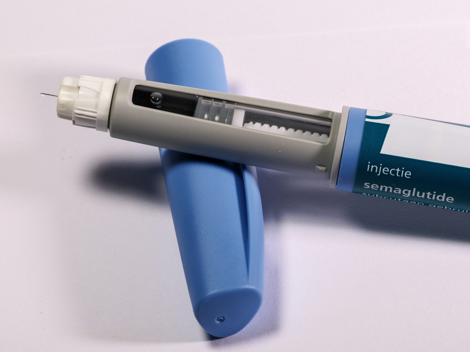 Close-up of a medical auto-injector pen lying on a light surface